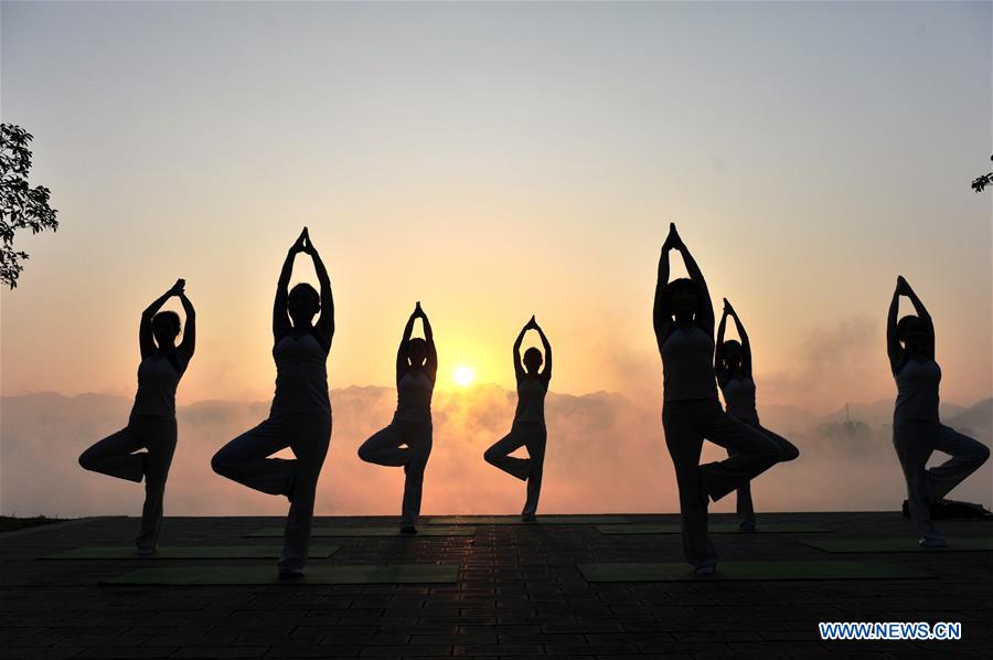 Yoga fans practice in sunset glow in China's Hu