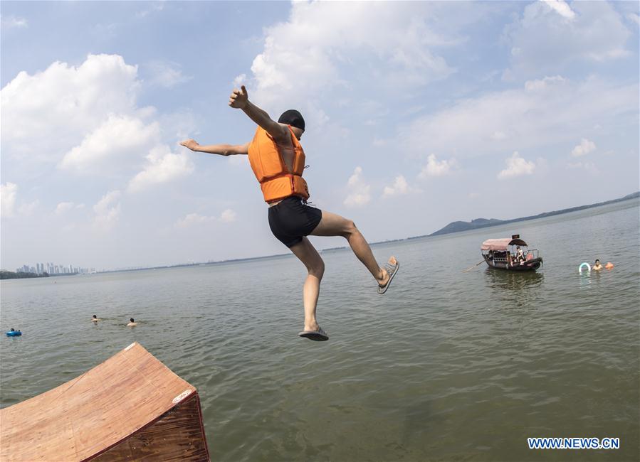 People jump into water to cool off amid hot weather in Wuhan CHINA-WUHAN-DONGHU LAKE-JUMP (CN)