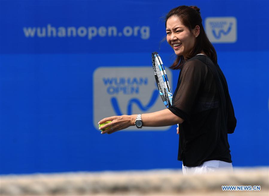 Li Na shows tennis skills to young players durin