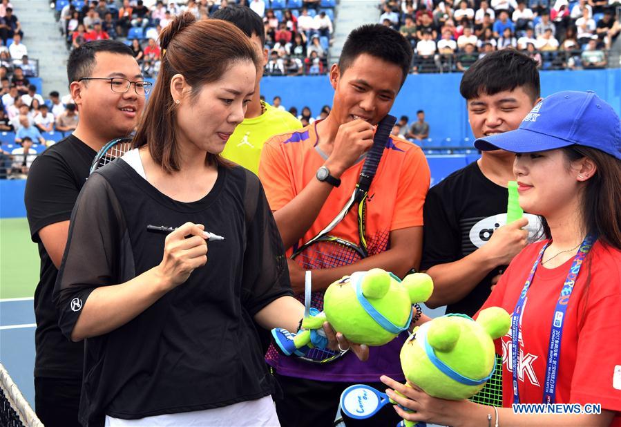 Li Na shows tennis skills to young players durin