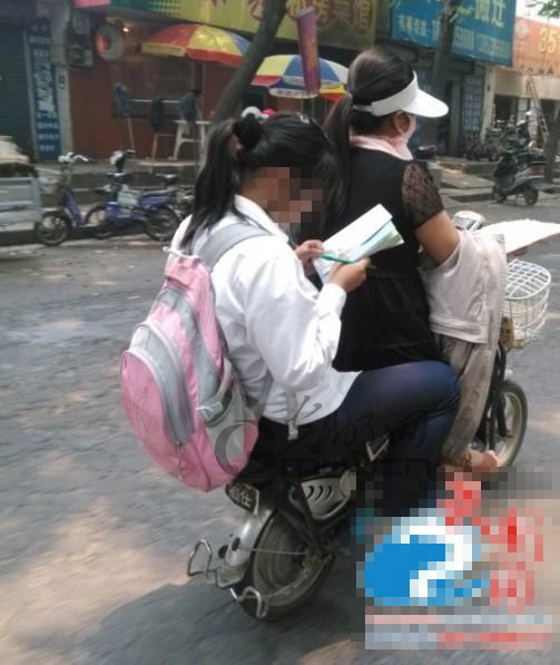 淮安一中学生坐电瓶车上写作业 市民直呼好危