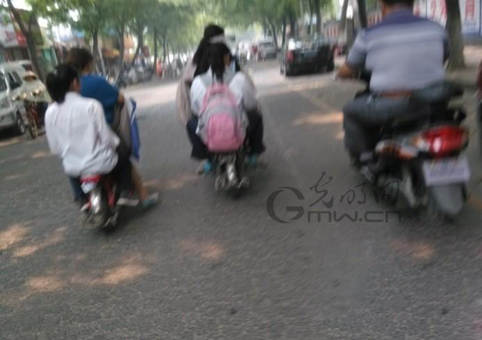 淮安一中学生坐电瓶车上写作业 市民直呼好危