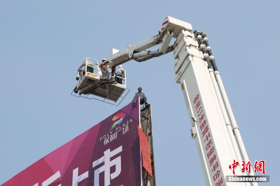 广西一精神病史男子爬上广告牌被救下(3)