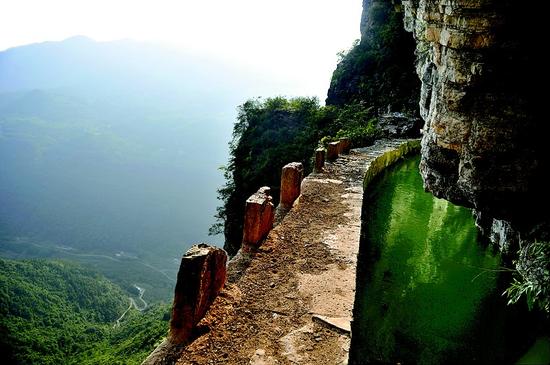 图为：绝壁窄堤，走一步尚且胆颤心惊，当年却是一点一点人工垒起来的。