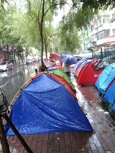 家长提前8天雨中支帐篷排队 让孩子上公办幼儿园