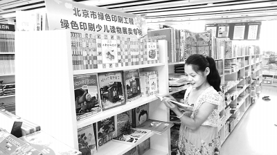 图为一名小读者在北京中关村图书大厦的绿色印刷少儿读物展卖专柜前看书。本报记者