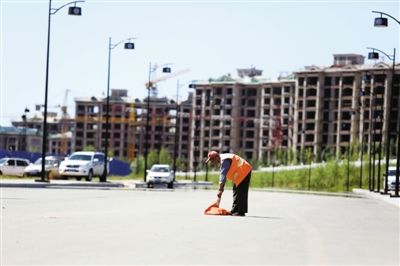 7月17日，康巴什新区，一名清洁工在清扫街道。