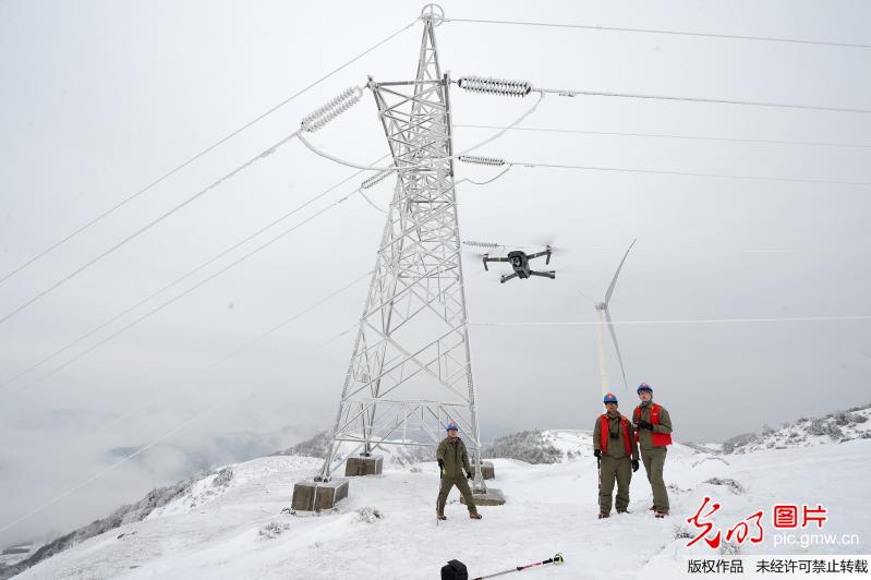 Workers inspect power transmission lines after heavy snowfall in C China