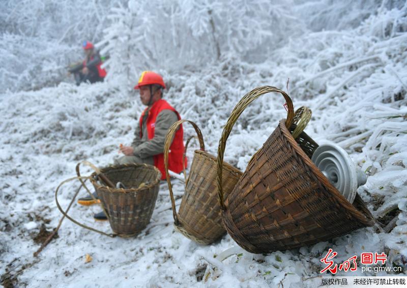 Workers inspect power transmission lines after heavy snowfall in C China