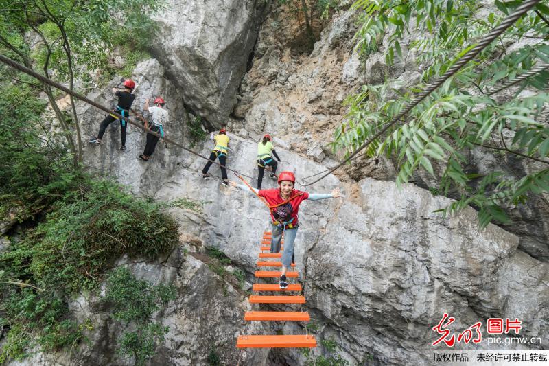 Tourists experience rock climbing in SW China’s Chongqing