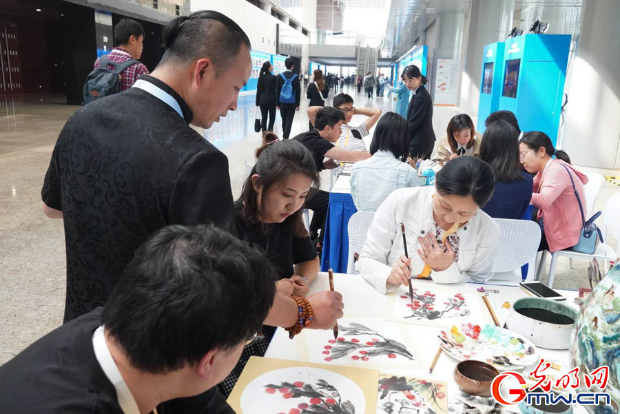 Chinese and foreign journalists experience intangible cultural heritages at CDAC media center in Beijing