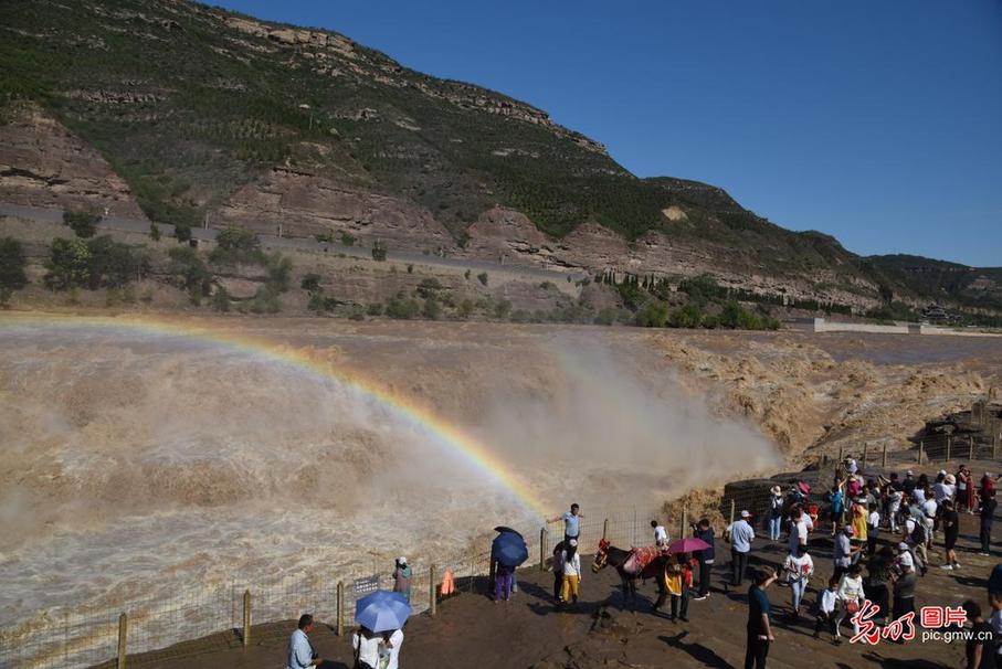 People enjoy the Hukou waterfall in N China's Shanxi