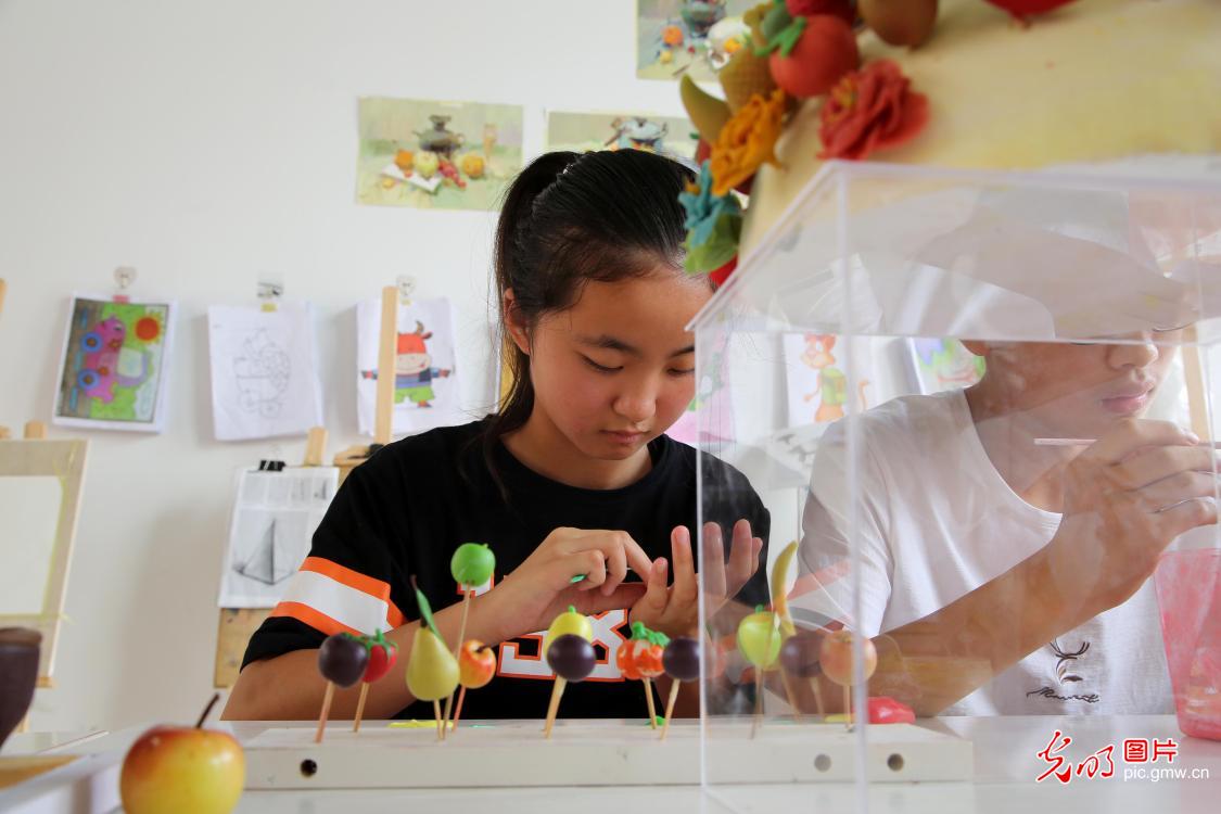Students learn dough modeling on summer vacation in east China’s Jiangsu