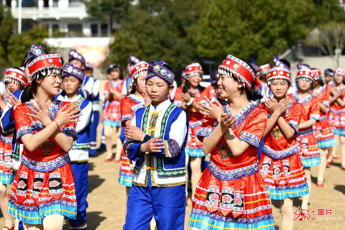 Students performing Yao folk dance in C China's Hubei