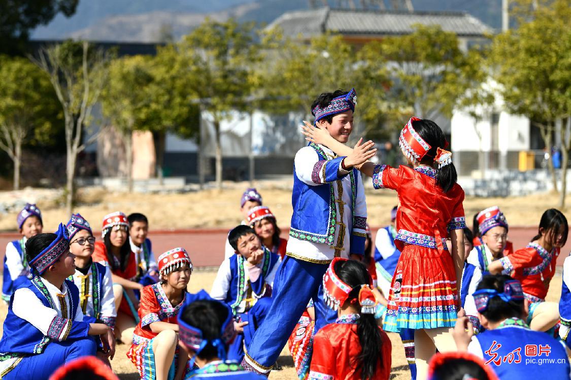 Students performing Yao folk dance in C China's Hubei