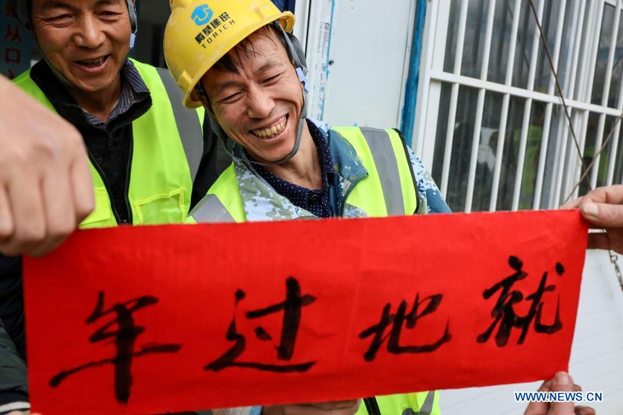 Workers celebrate upcoming Spring Festival at construction site in Guizhou