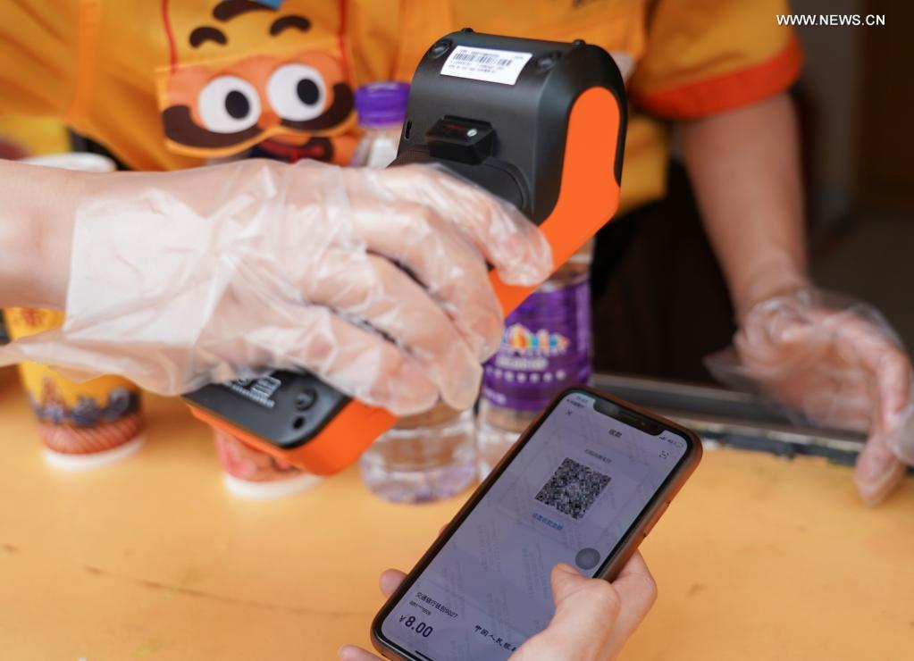 People experience digital RMB at Happy Valley Beijing theme park