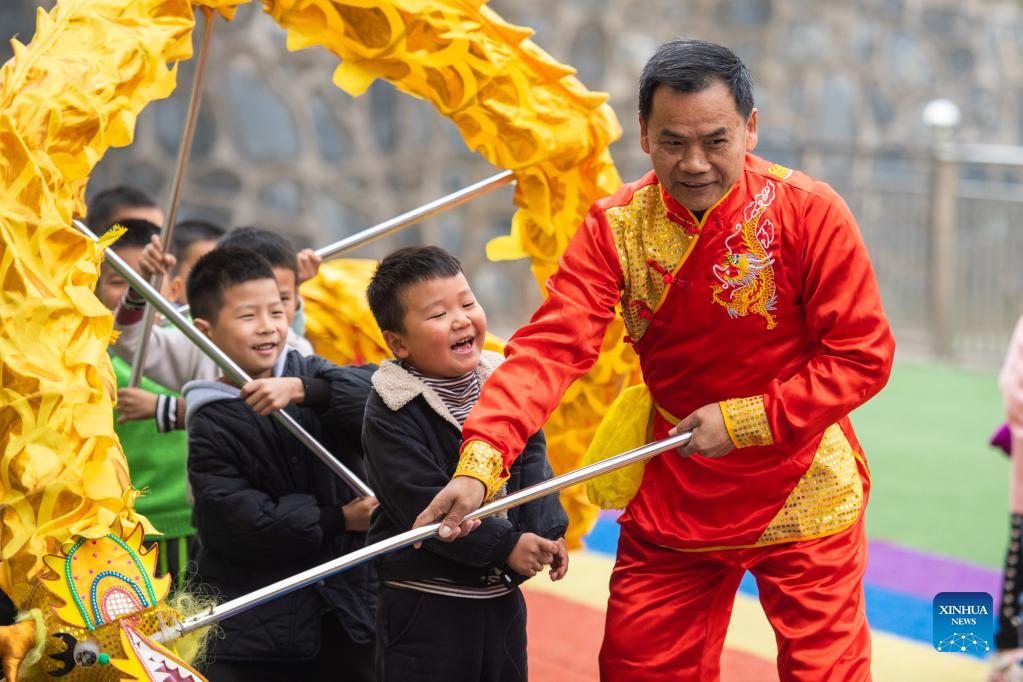 Children learn dragon dance from folk artist at kindergarten in Hunan
