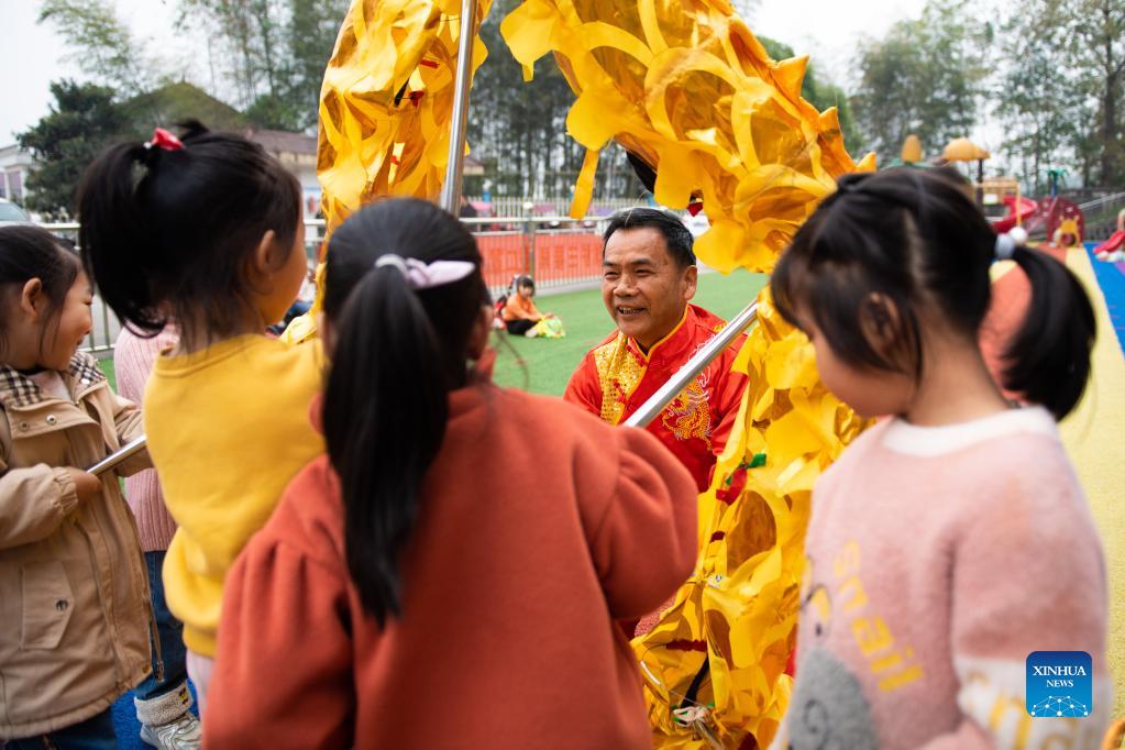 Children learn dragon dance from folk artist at kindergarten in Hunan