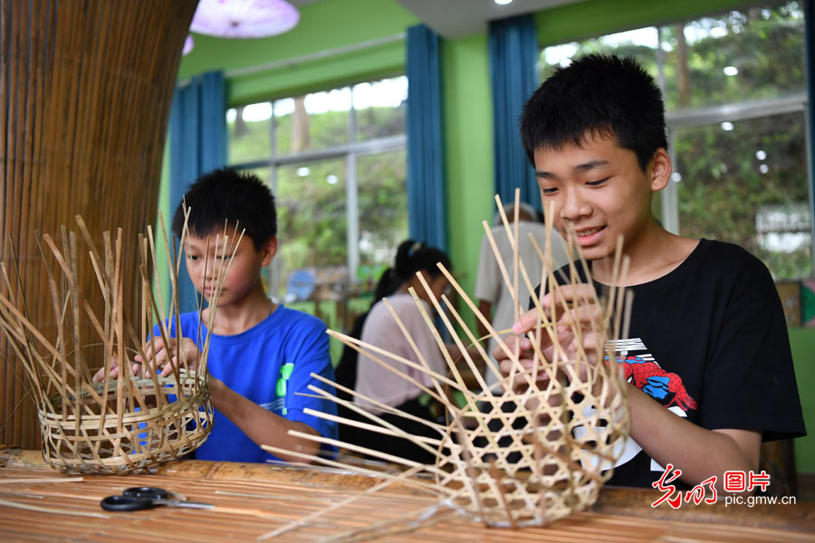 Folk craftsman teaches high school students bamboo weaving technique in E China's Jiangxi