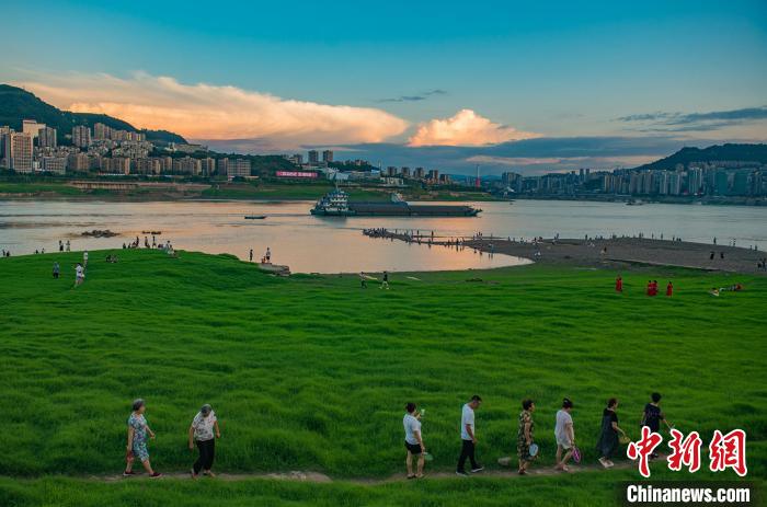 重庆万州，民众在长江消落带草坪上游玩。　侯本艳 　摄