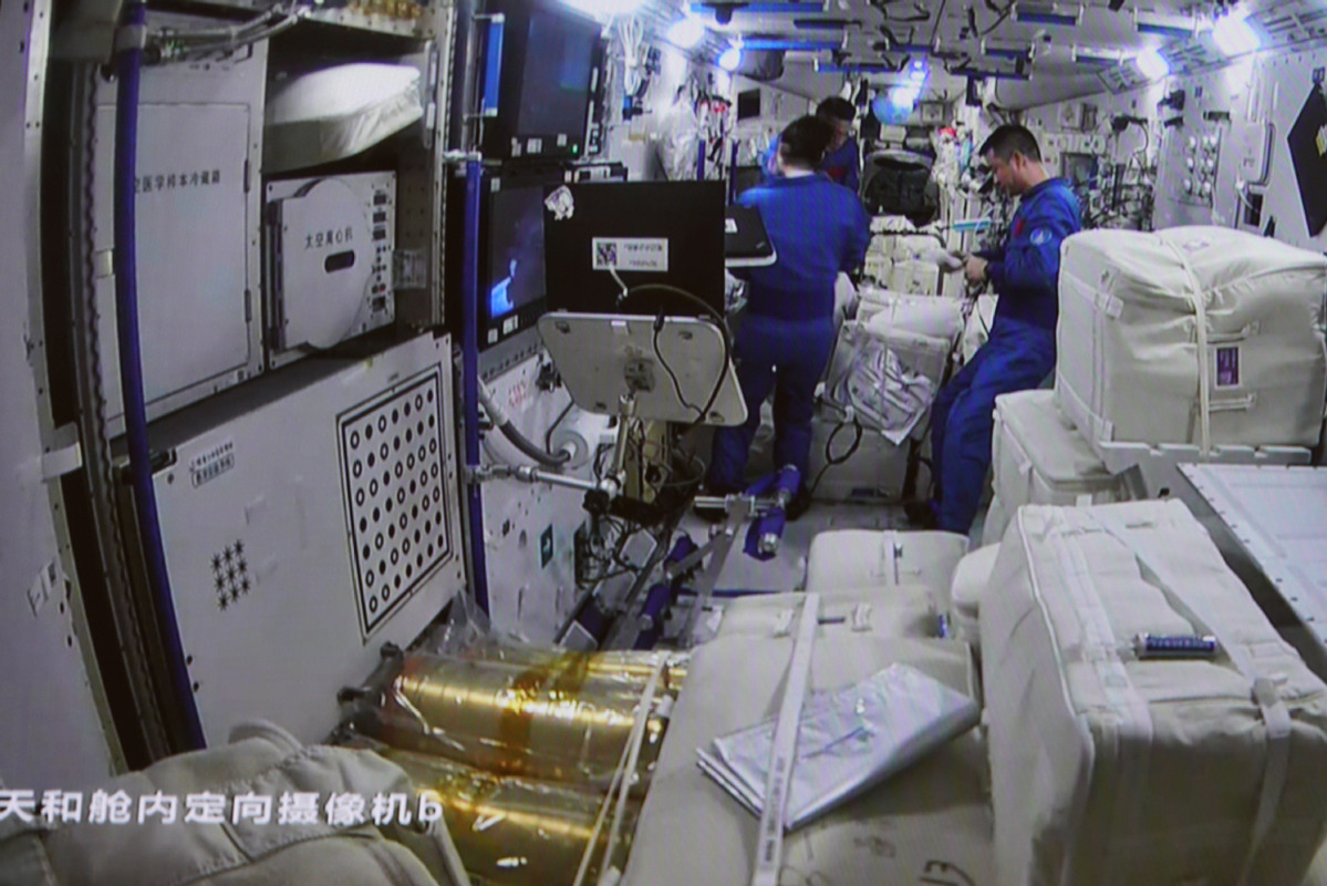 Astronauts transferring cargo into space station