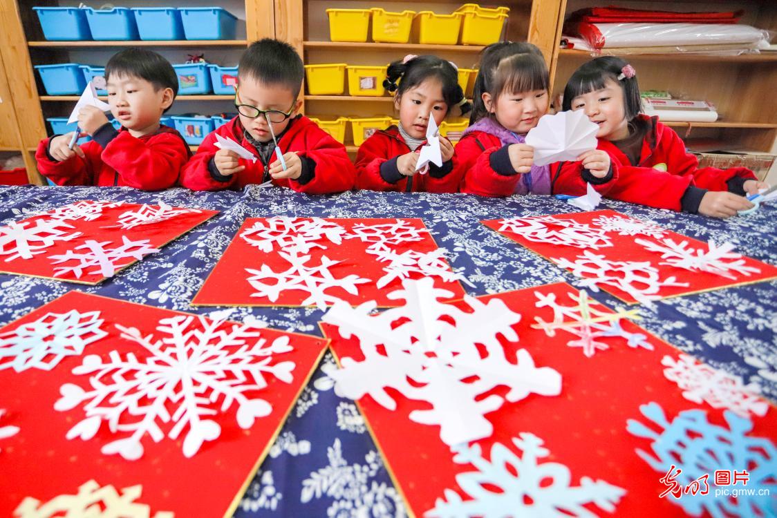 Children make snowflakes papercut to welcome Light Snow in E China's Zhejiang