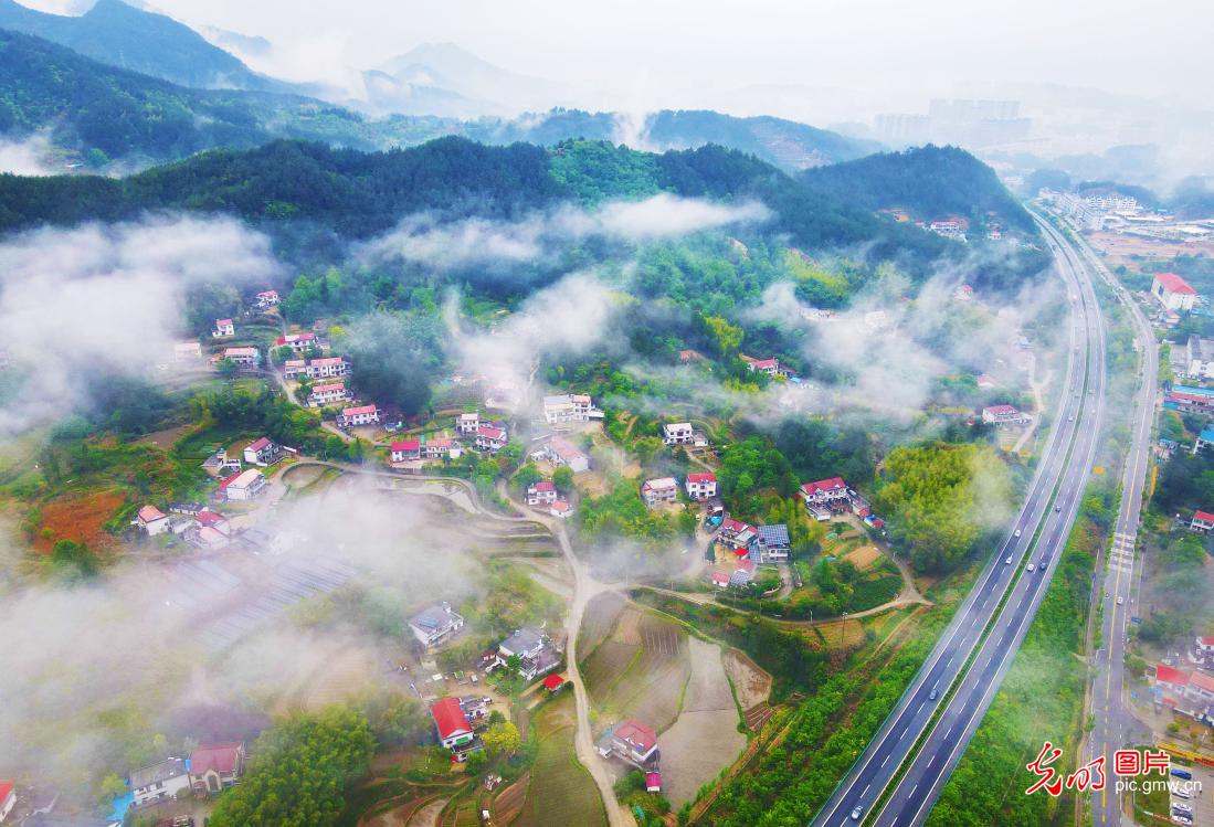 Village shrouded by cloluds and fog in E China's Anhui