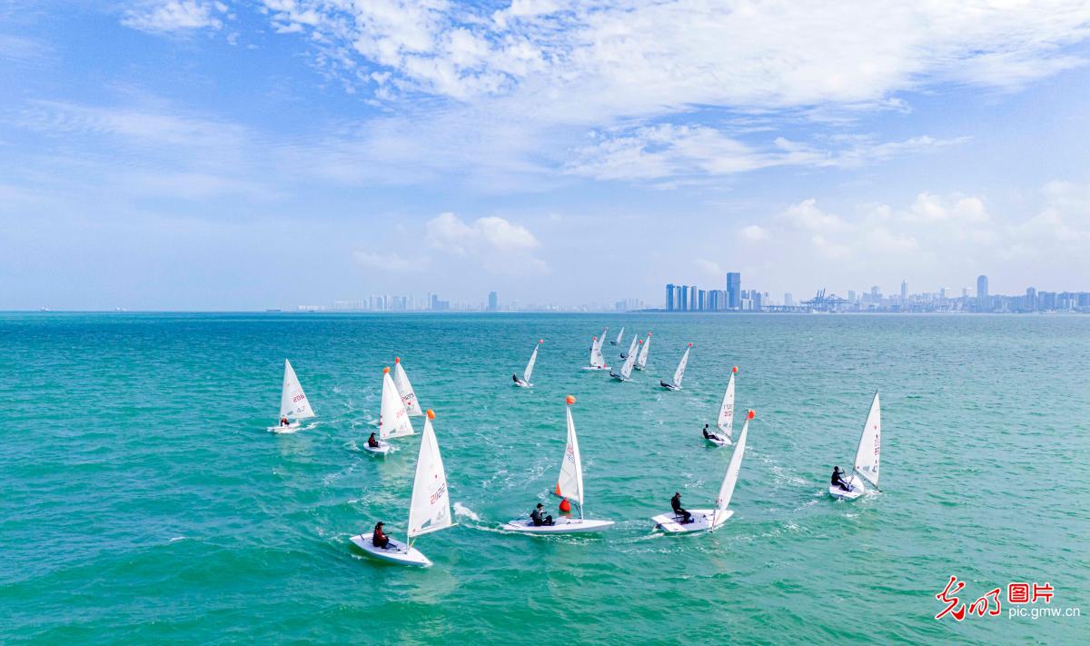 Sailing boat trainees riding wave at West Bank in S China's Hainan Province