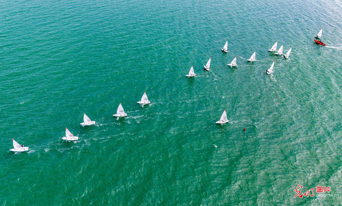 Sailing boat trainees riding wave at West Bank in S China's Hainan Province