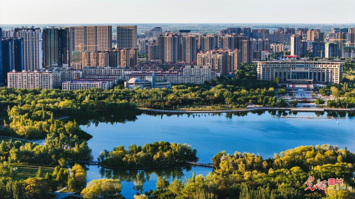 Changji City of NW China’s Xinjiang: Green trees and river surround city with picturesque view