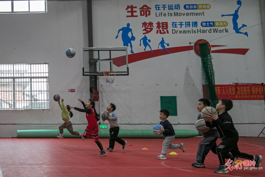 Student practice basketball in winter vacation in S China's Guangxi