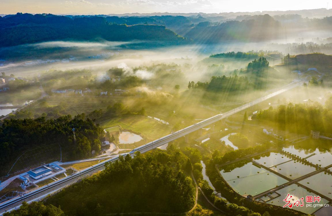 Morning light pierces the veil of mist over rural areas of Chongqing in SW China