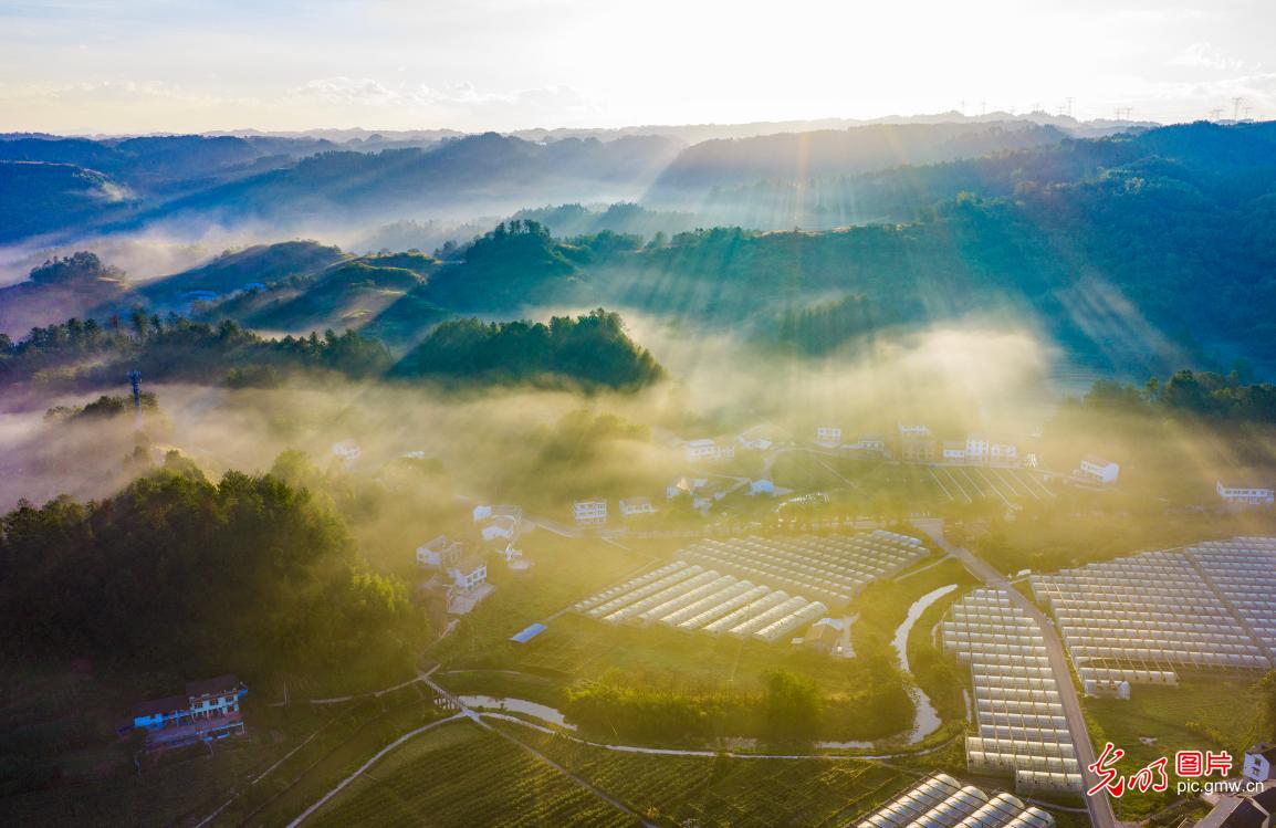 Morning light pierces the veil of mist over rural areas of Chongqing in SW China