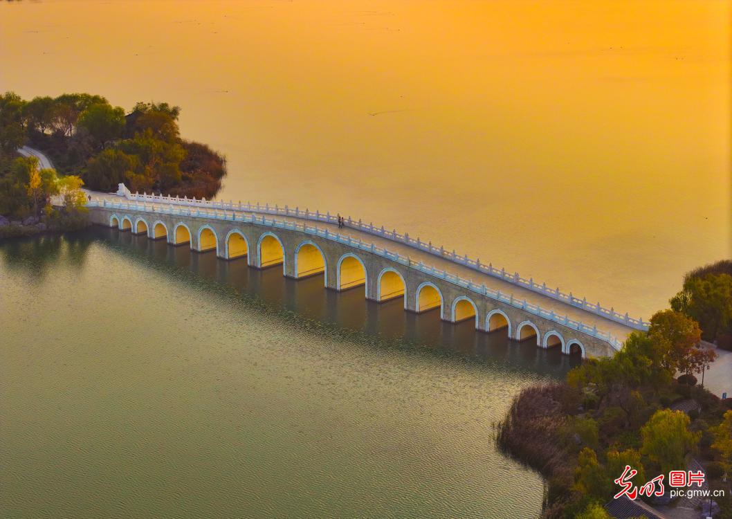 Golden sunlight shines through bridge arches at Nanhu Wetland Park Golden sunlight shines through bridge arches at Nanhu Wetland Park