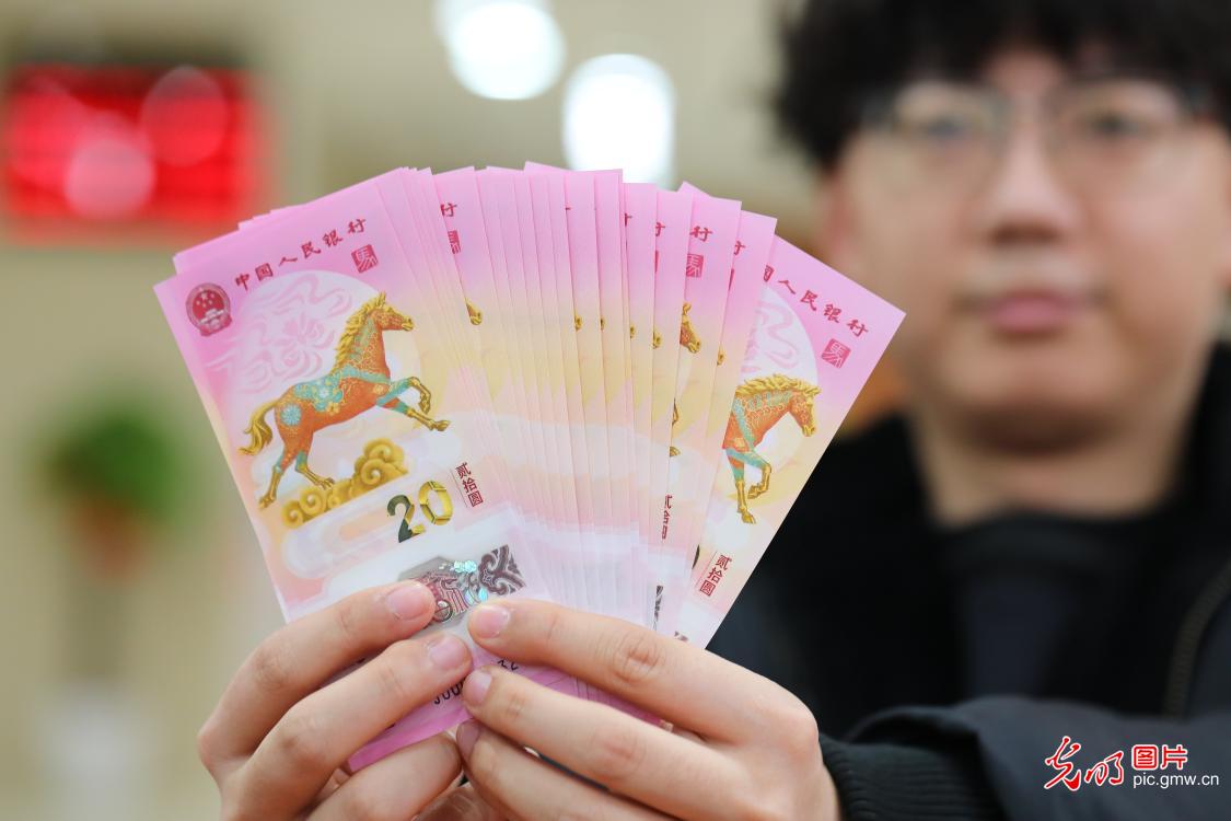 Citizens collect 2026 Chinese New Year commemorative banknotes, coins