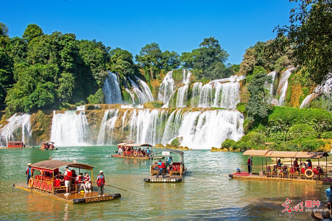 Tourists enjoy scenic views at waterfall in S China's Guangxi Tourists enjoy scenic views at waterfall in S China's Guangxi