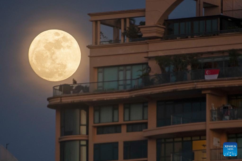 Moon rises in sky above Singapore