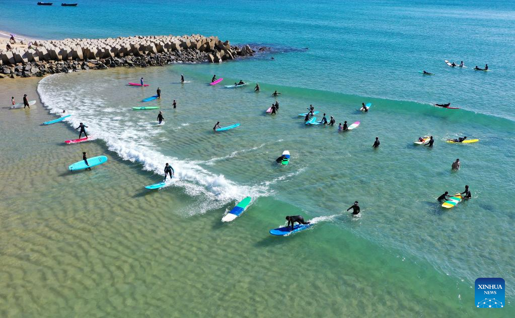 Tourists go surfing in Wanning, S China