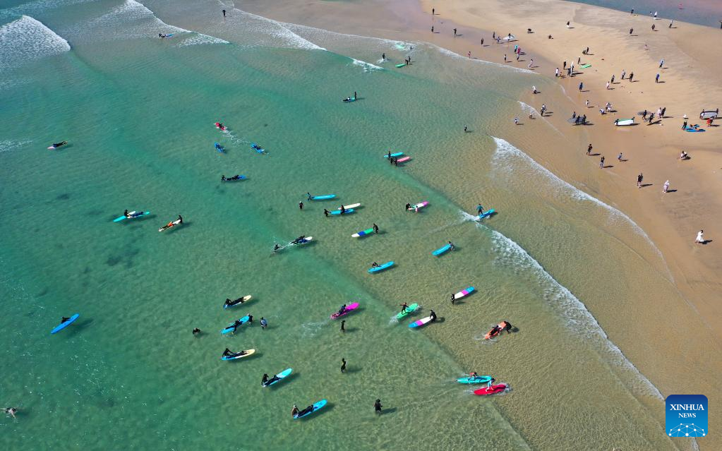 Tourists go surfing in Wanning, S China