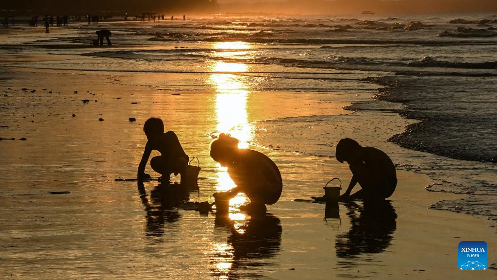 Tourists have fun at Jintan beach in Dongxing, S China's Guangxi