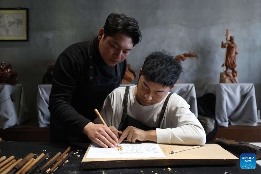 Pic story of inheritor of Huizhou woodcarving in E China
