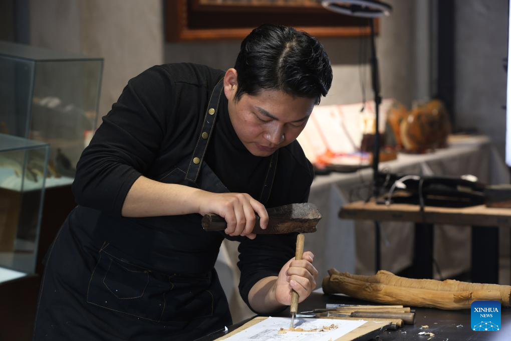 Pic story of inheritor of Huizhou woodcarving in E China