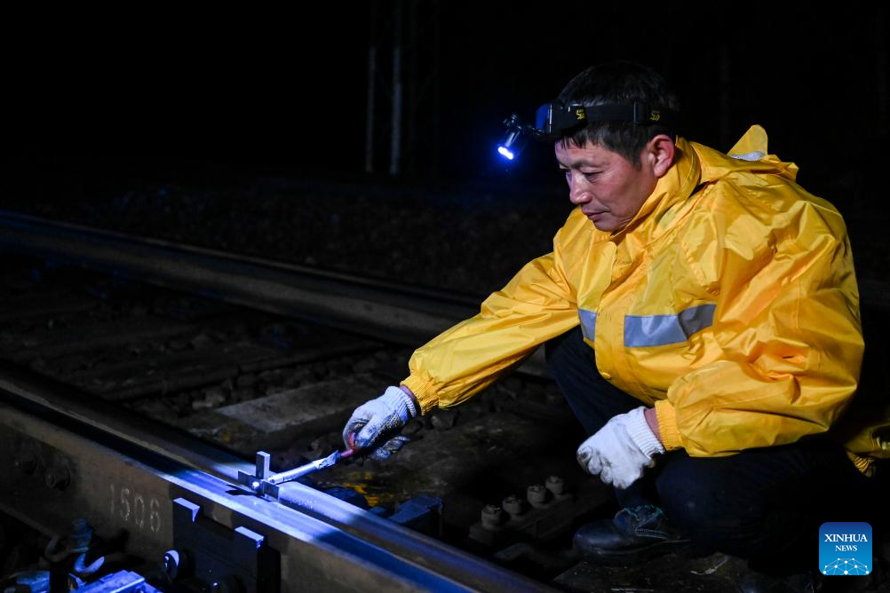 Railway maintenance workers ensure smooth operation of signal equipment in S China
