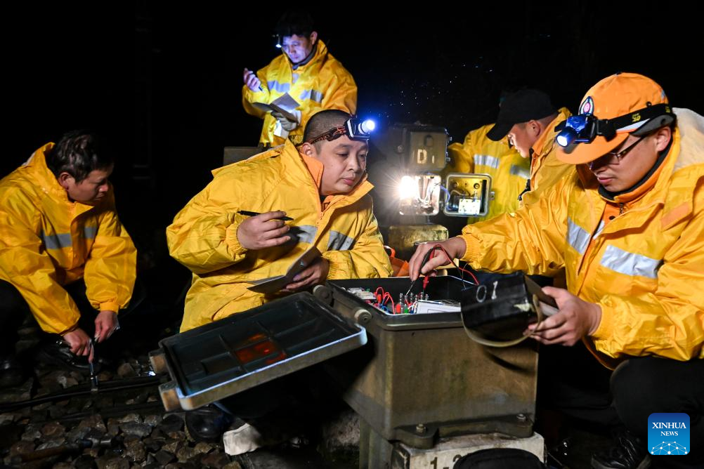 Railway maintenance workers ensure smooth operation of signal equipment in S China