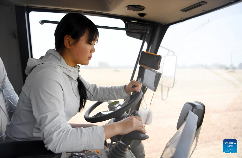 Pic story: female operator aids villagers with combine harvester