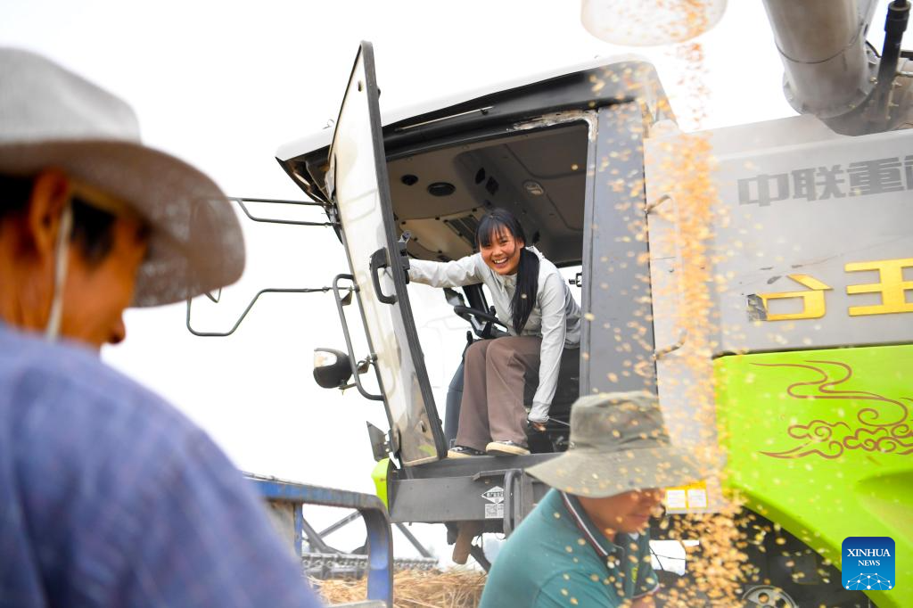 Pic story: female operator aids villagers with combine harvester