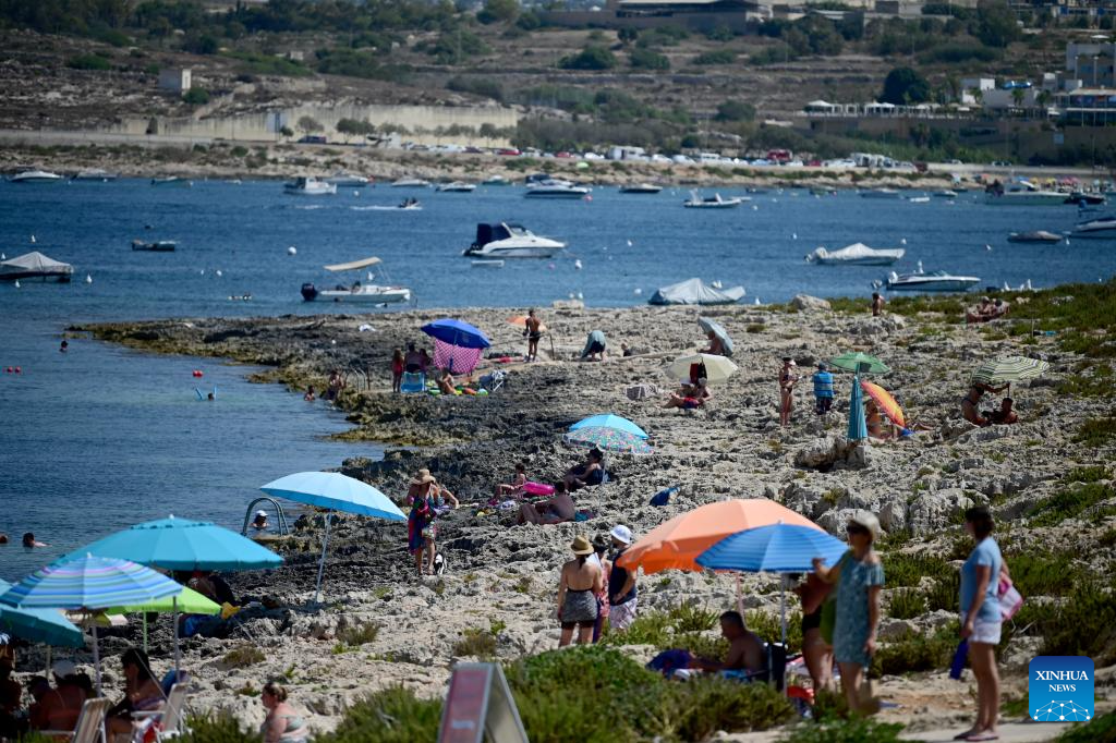 People cool off at St. Paul's Bay in Qawra, Malta