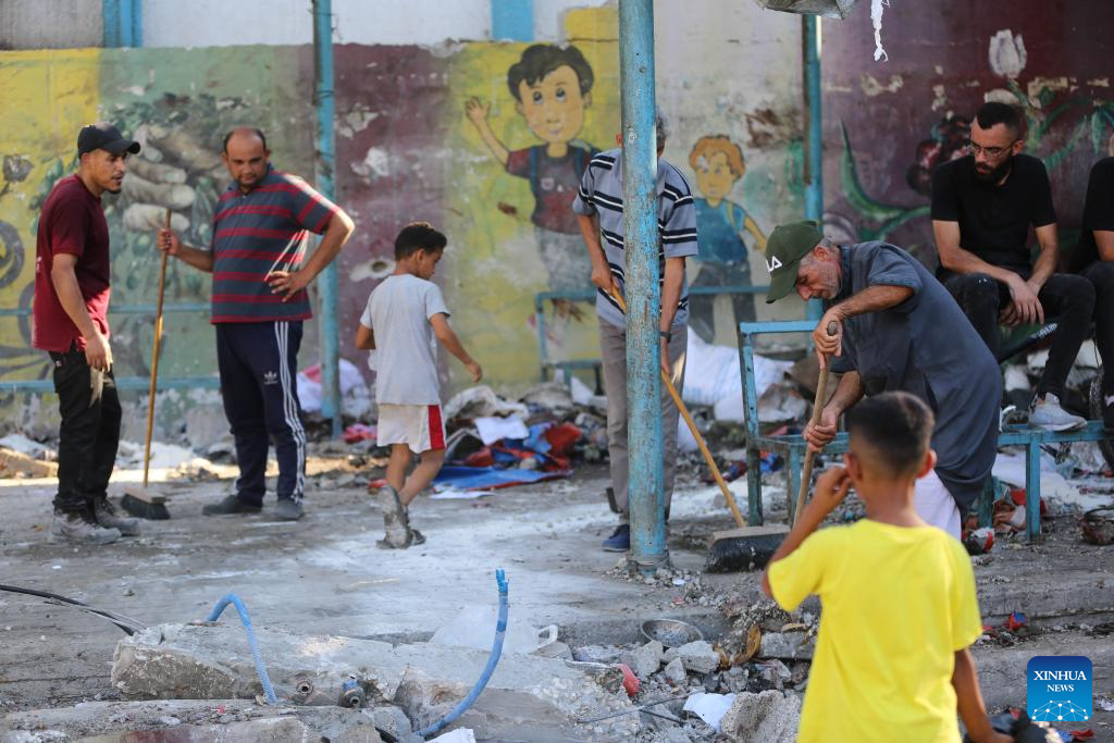 People conduct clean up work at UN-affiliated school after Israeli attack in Gaza