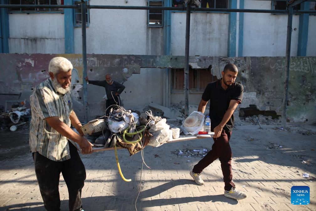 People conduct clean up work at UN-affiliated school after Israeli attack in Gaza